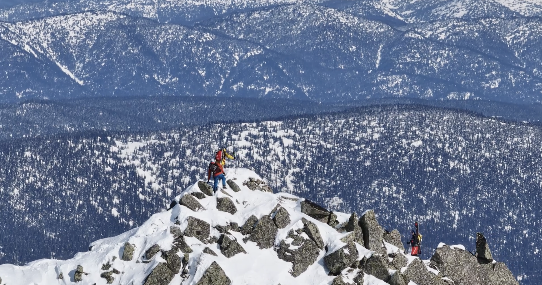 Man on top of a snowcapped mountain